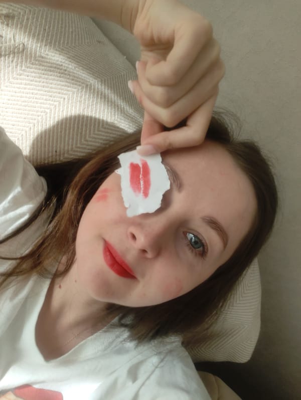 Woman plays with lipstick-marked papers indoors
