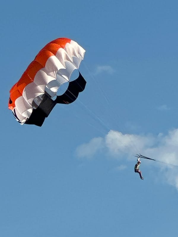 Beach day in Boreti with parasails flying overhead