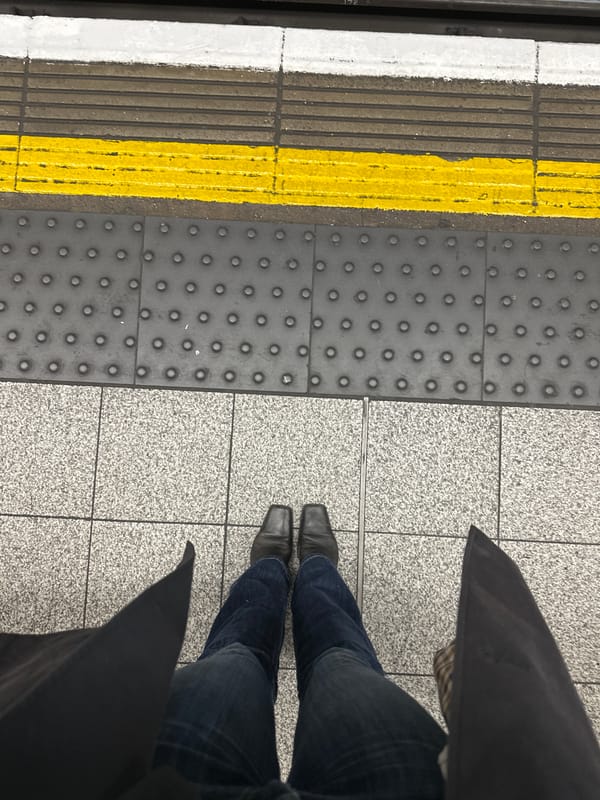 Commuter waits on London Underground platform during morning hours