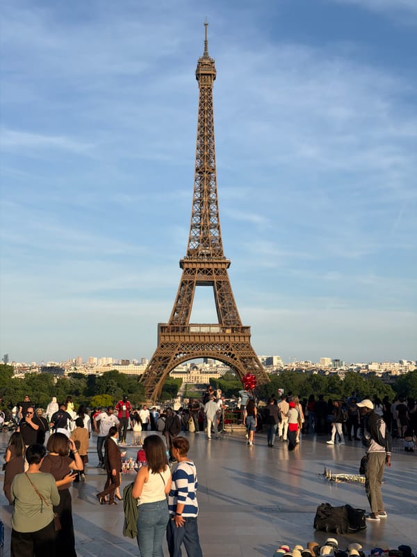 Tourists photograph Eiffel Tower under clear Paris skies