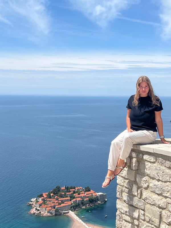 Tourists photograph and exercise at Sveti Stefan coastal overlook