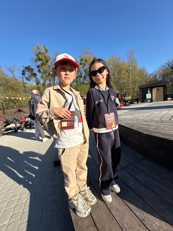 Two children pose together on wooden deck