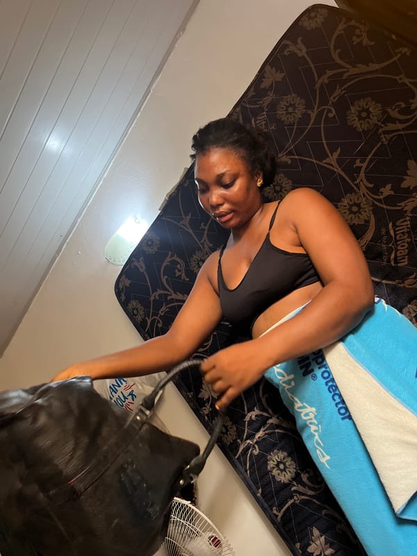 Woman resting on mattress in Abuja room