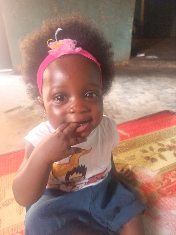 Child sits on mat at home in Akwanga, Nigeria