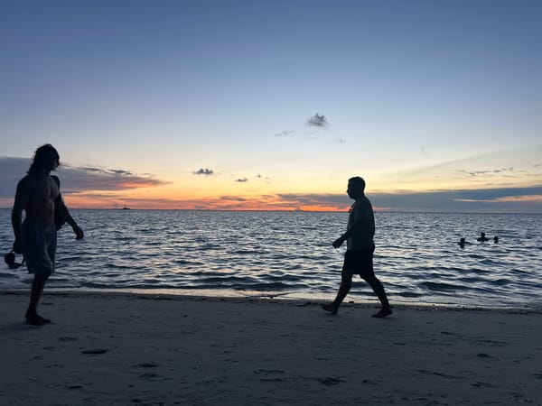 Koh Phangan beach at golden hour, crowds winding down