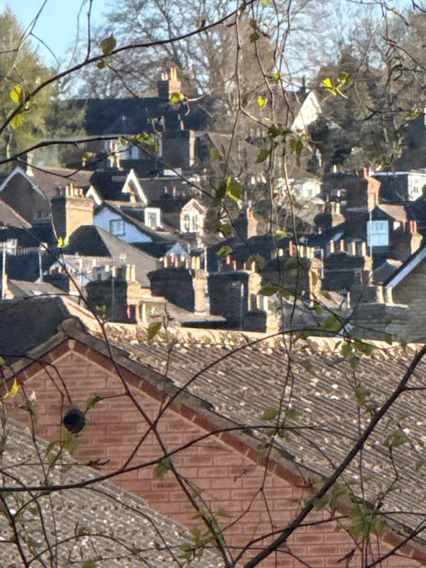Man tends narrowboat on Hertfordshire canal during afternoon