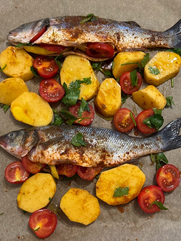 Whole sea bass prepped with tomatoes, lemon, and potatoes