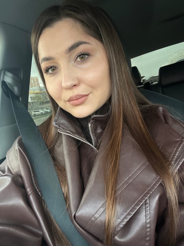 Woman drinks coffee while driving through rainy Moscow morning traffic