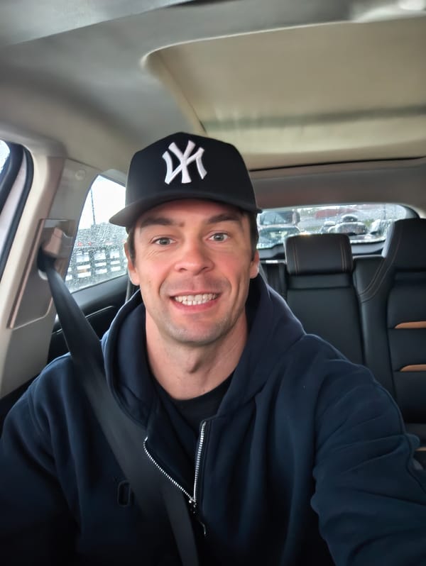 Man in Yankees cap takes car selfies during Moscow rain