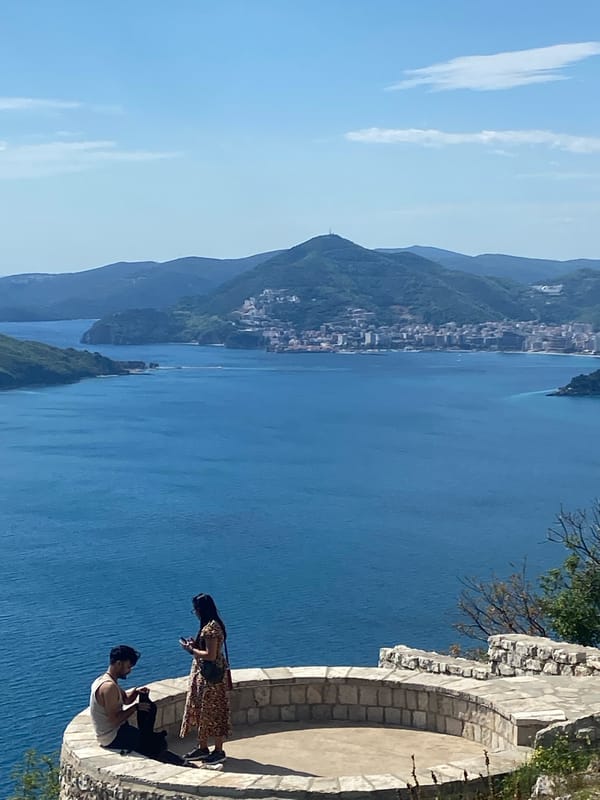 Two visitors enjoy coastal views at Sveti Stefan Montenegro