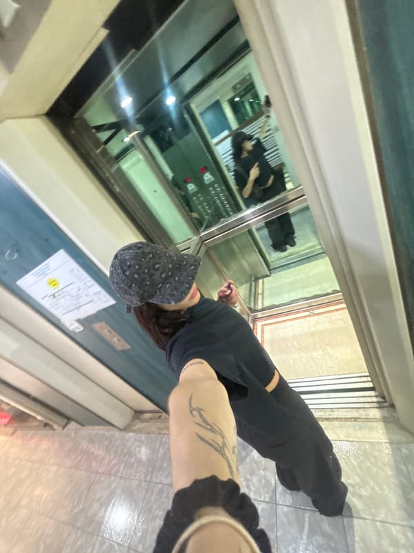 Person with tattoo, patterned cap observed in Buenos Aires elevator