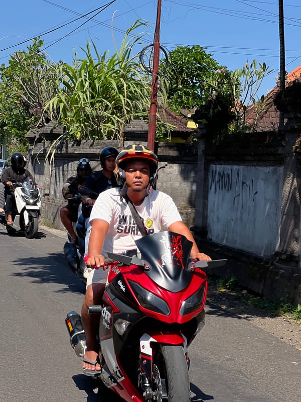 Motorcycle traffic flows through sunny Denpasar streets