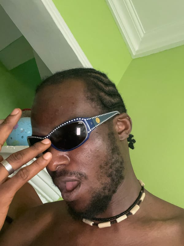 Person with sunglasses and beaded necklace captured indoors