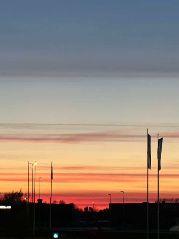 Dramatic sunset photographed over Aalborg streets during evening twilight
