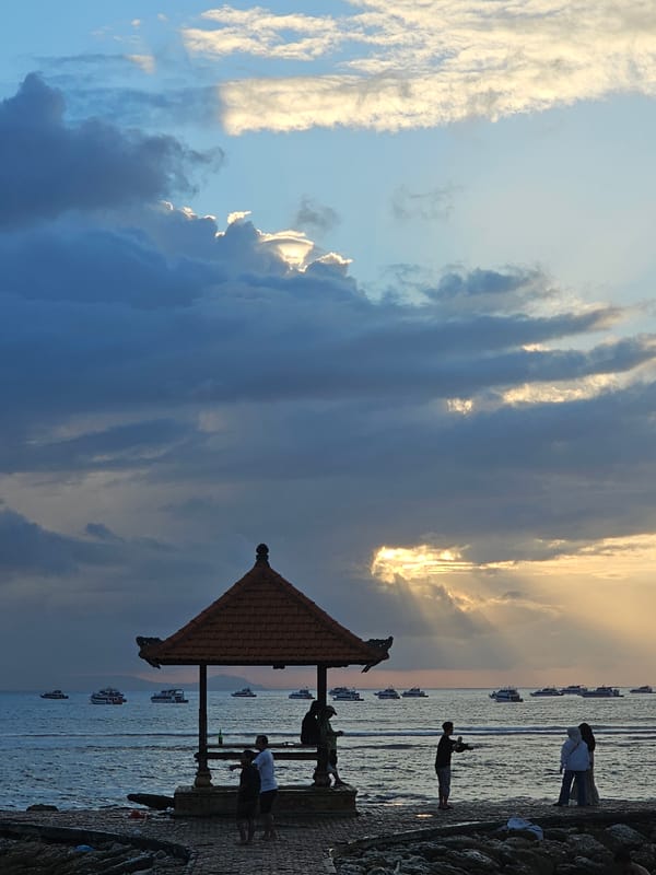 Denpasar coastline at golden hour, boats and beachgoers