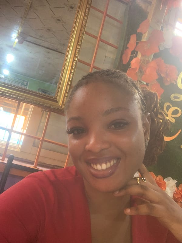 Woman photographs herself at indoor event with decorative backdrop