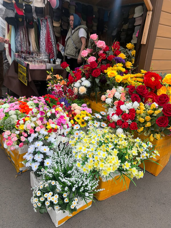 Street vendor sells flowers, accessories at Shushary market