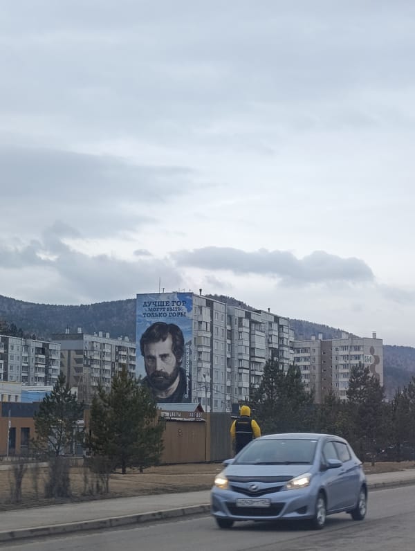 Overcast morning captures Krasnoyarsk apartment buildings and worn roads