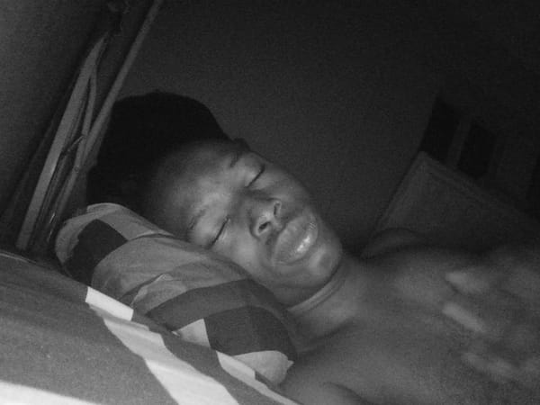 Person rests in bed during early morning in Lagos