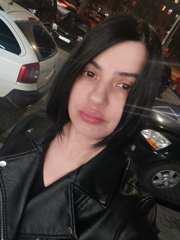 Woman in leather jacket photographed in urban nighttime setting