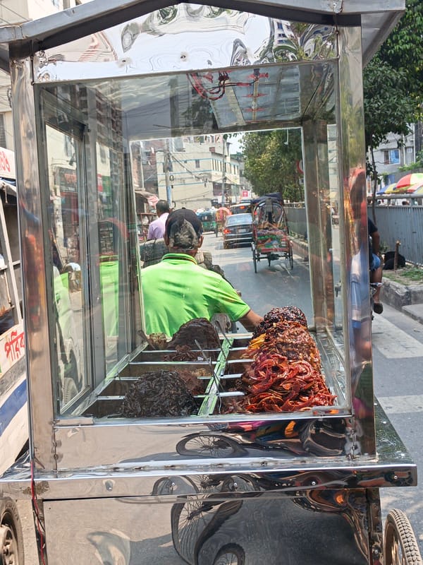 Street vendors operate mobile carts in morning Dhaka traffic