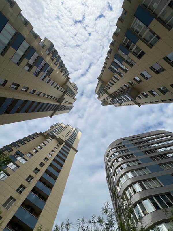 Looking up at Moscow's modern residential towers on a cloudy afternoon