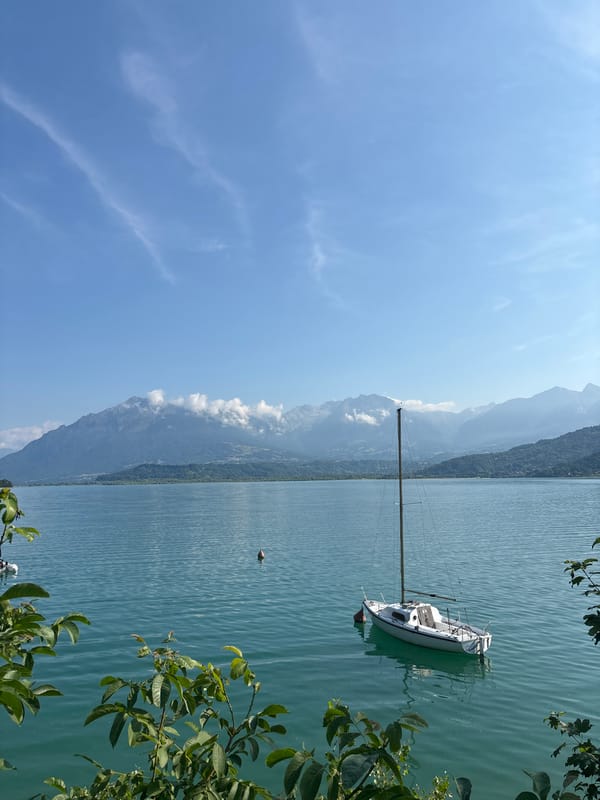Sailboat anchored on a misty alpine lake in northern Italy