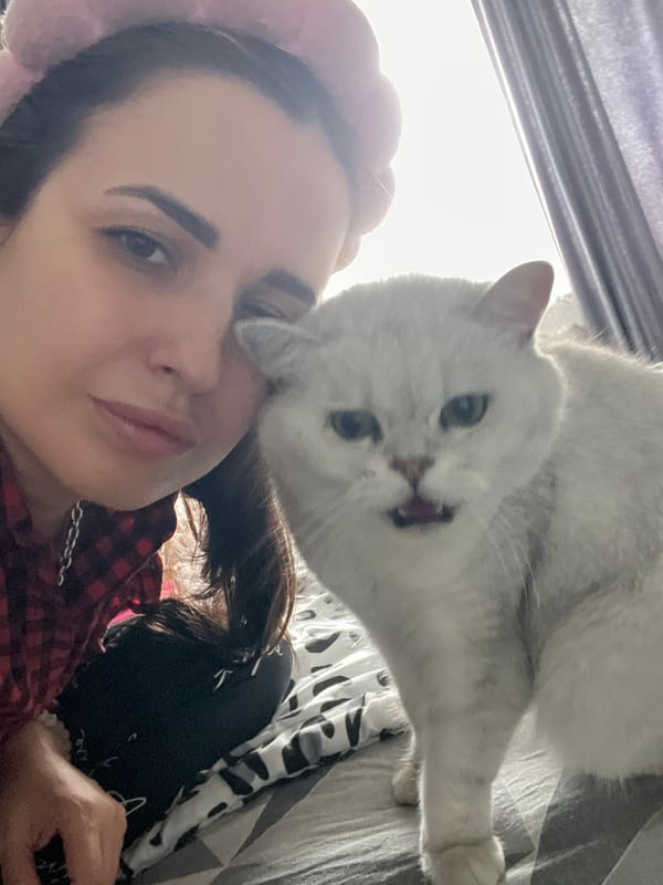 Woman in plaid shirt spends quiet moments with gray cat