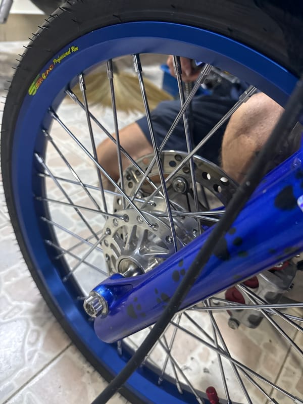 Blue motorcycle teardown and fuel prep in a Si Sunthon garage