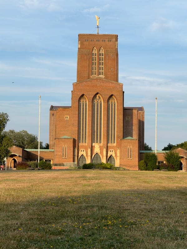Guildford Cathedral's brick Gothic exterior on a summer evening.