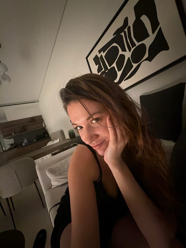Woman rests on bed in Athens interior setting