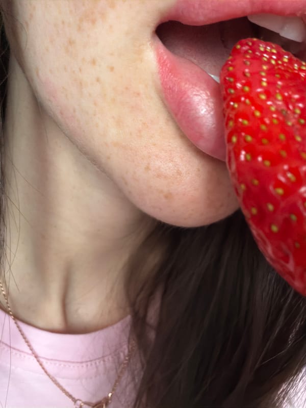 Person enjoys strawberries indoors in Saint Petersburg