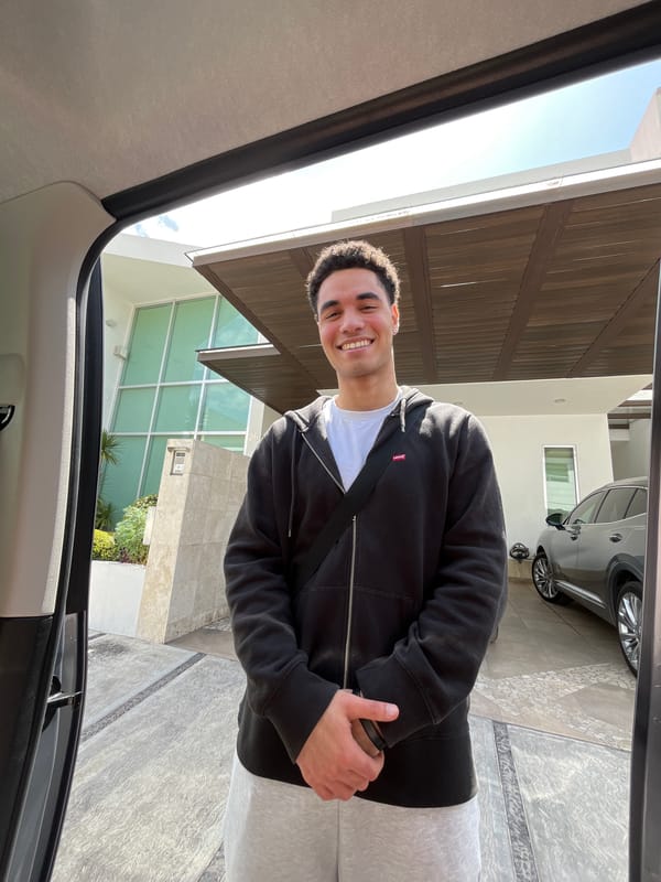 Man poses by house, vehicle trunk packed with supplies