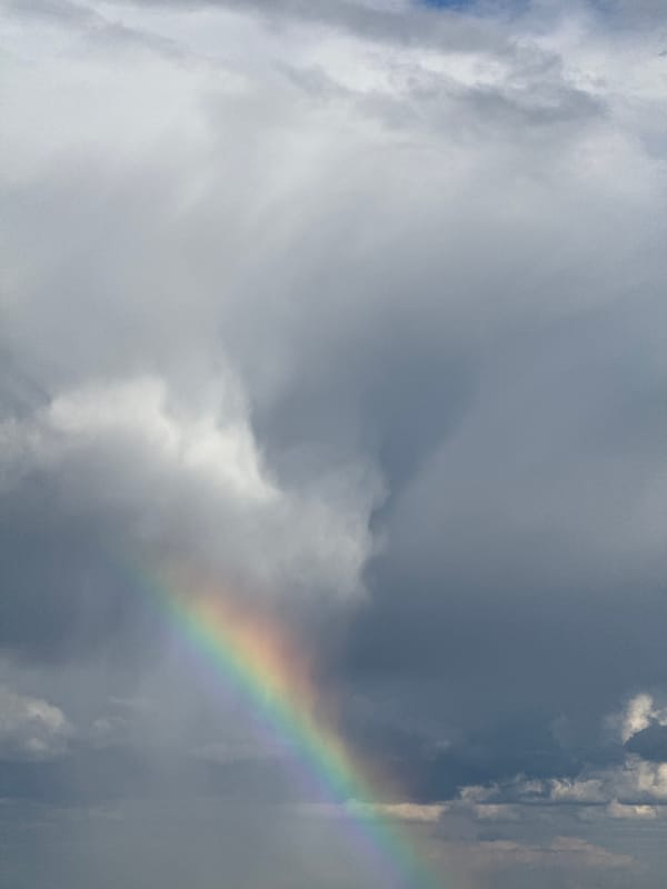 Rainbow appears over Poliudovo, Russia amid cloudy afternoon skies