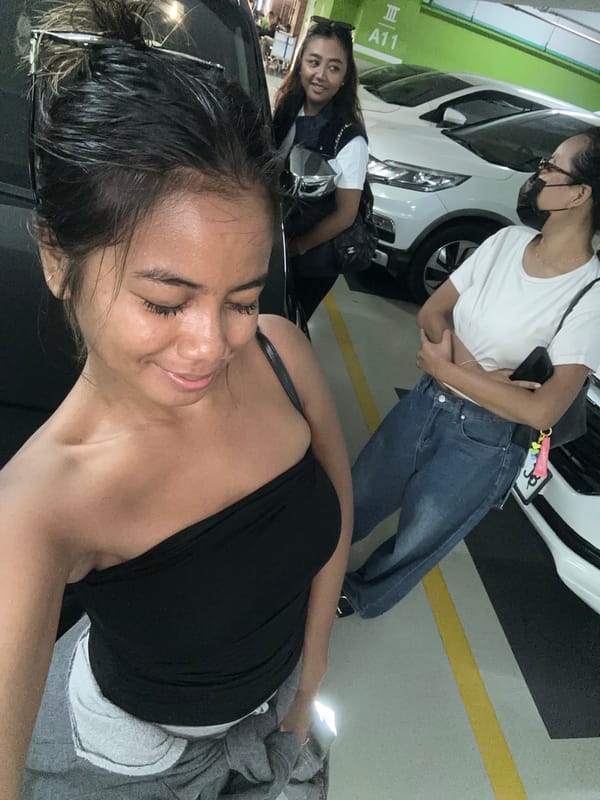 Parking garage activity in Kuta: selfies and a car inspection