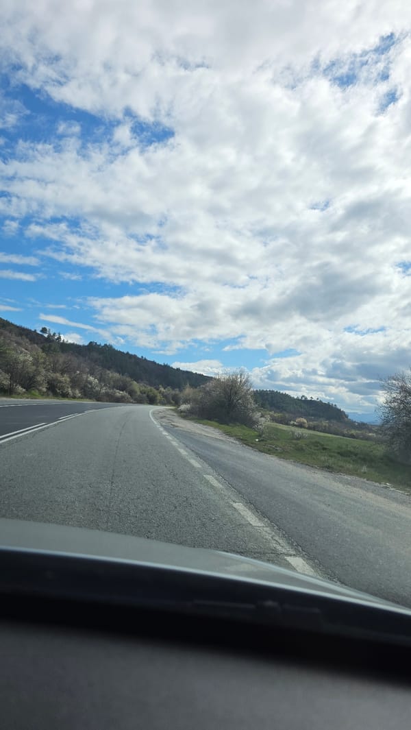Vehicle drives through hilly countryside near Kocherinovo, Bulgaria