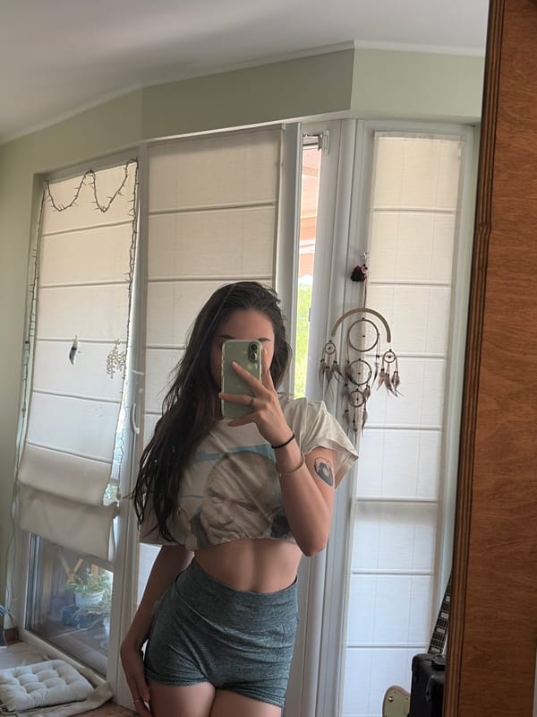 Mirror selfies and a pink guitar in a cozy bedroom setup