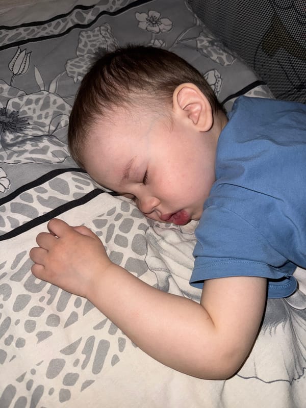 Toddler sleeps peacefully on patterned bedding in Yaroslavl