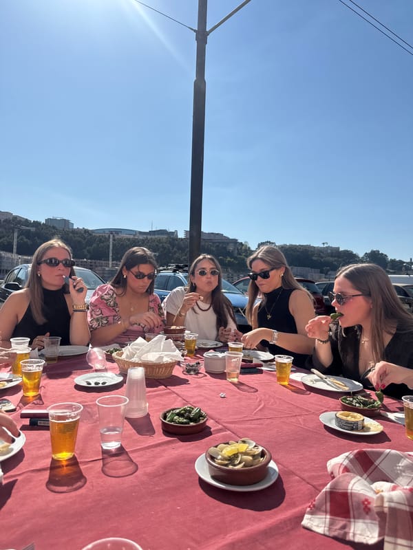 Five women enjoy outdoor lunch in sunny Porto