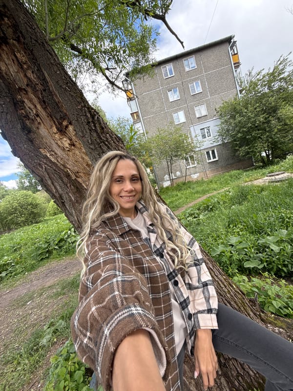 Woman rests on fallen tree in Russian residential area