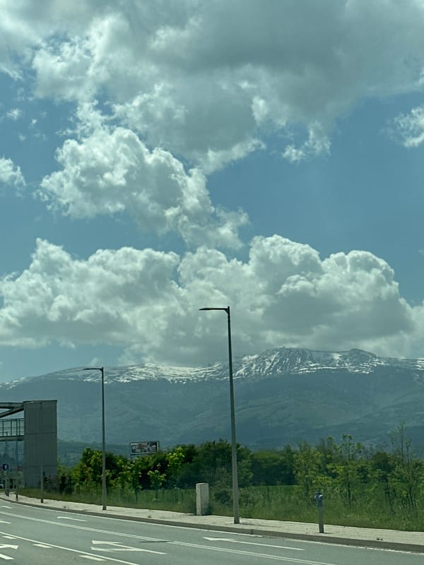 Snow-capped mountains visible from roadside in Lozen, Bulgaria