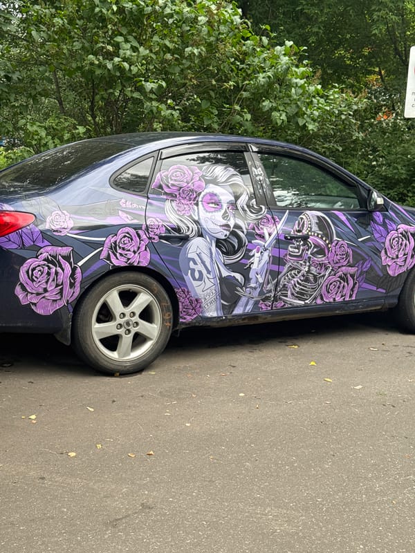 Vehicle display featuring decorated cars and military motorcycle