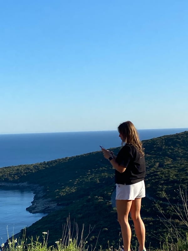 Woman photographs Adriatic coastline from Montenegro cliffs