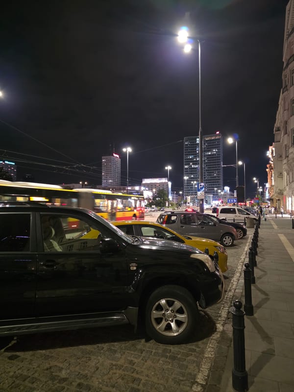 Central Warsaw at night — trams, towers, and ornate streets