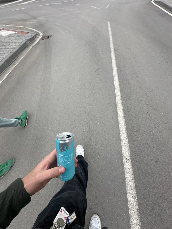 Person drinks Red Bull on street in Dryanovo