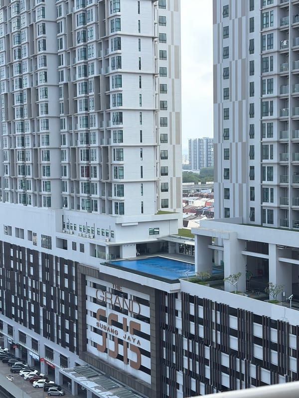 Twin residential towers rise over Subang Jaya's urban landscape.
