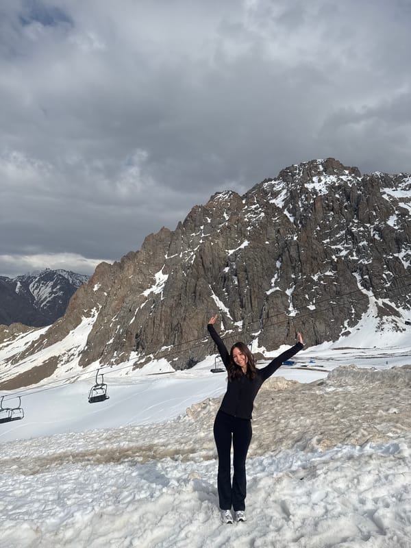 Woman poses on snowy slope at Almaty ski resort