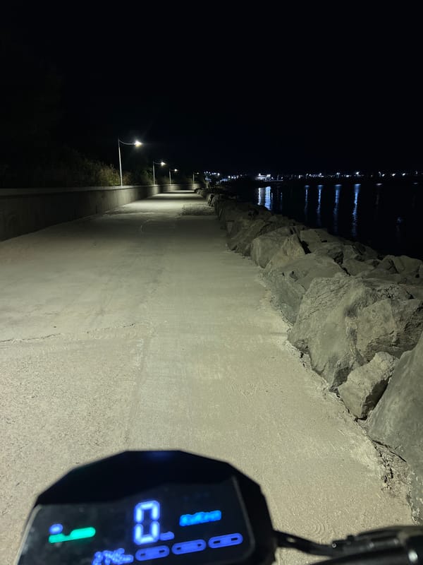 Parked e-scooter on Burgas waterfront breakwater at night