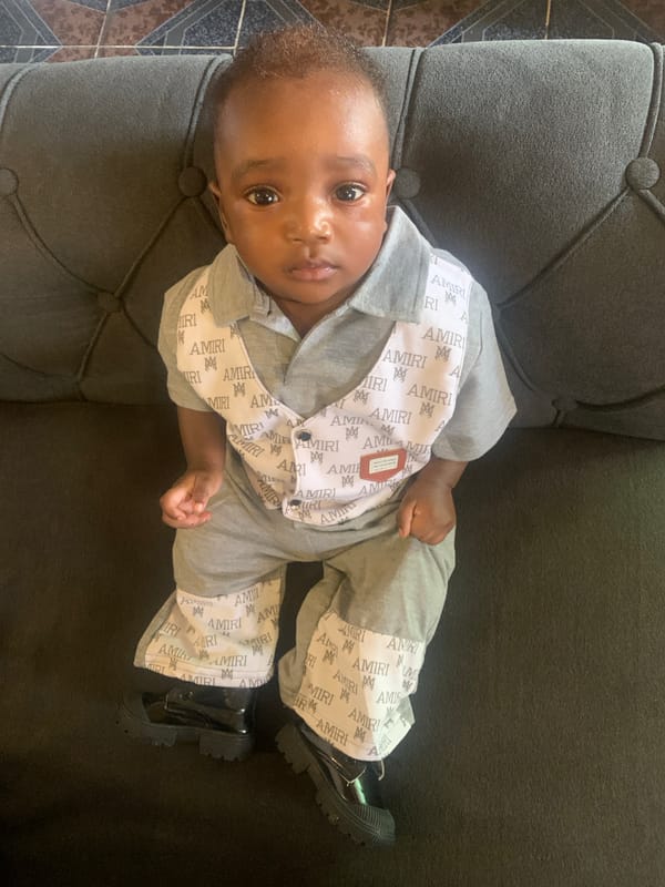 Baby in designer outfit photographed on couch in Nigeria