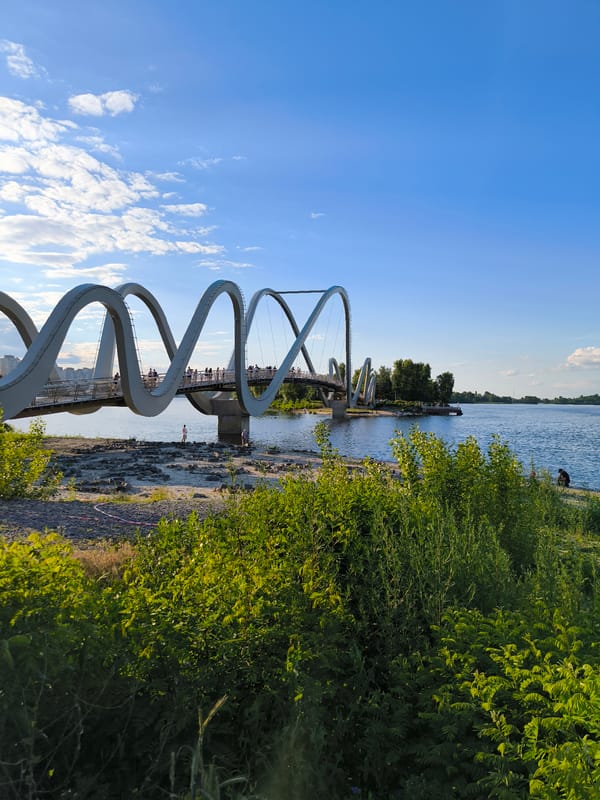 Kyiv's loop bridge and Dnipro embankment on a sunny afternoon